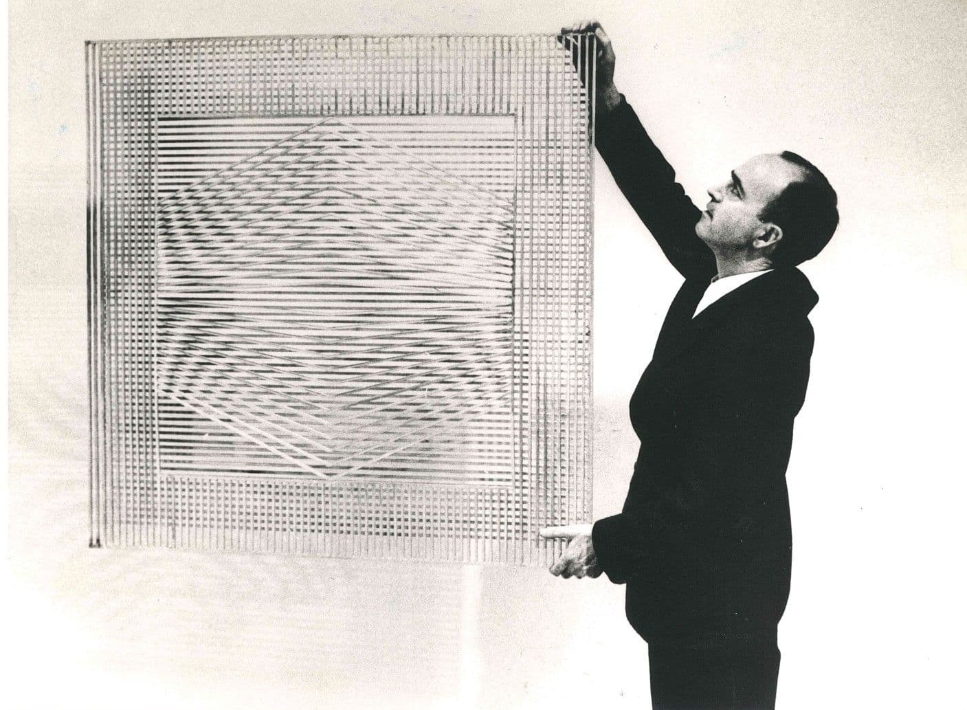 Eusebio Sempere sosteniendo su obra "Rejas"